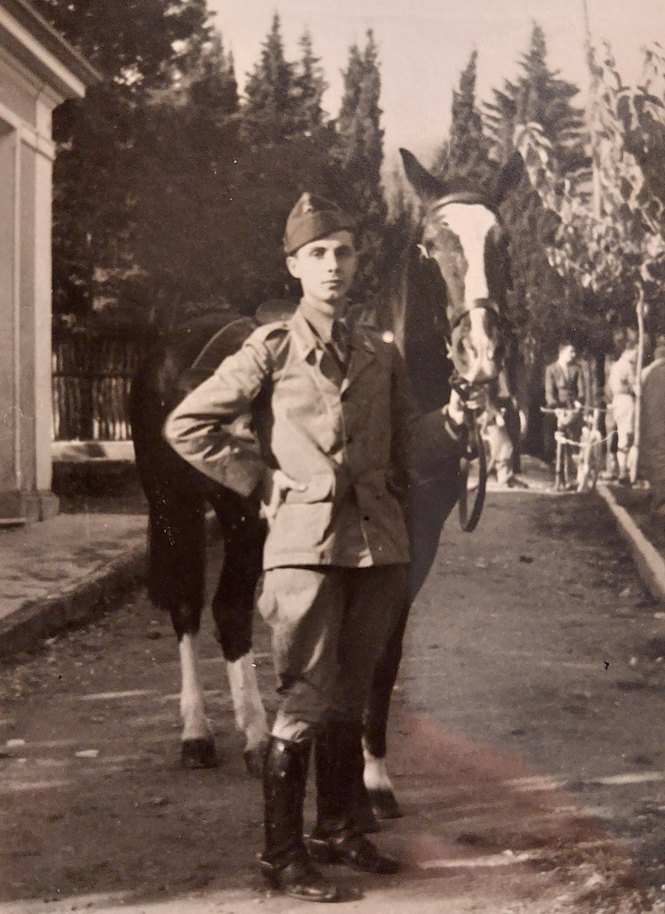 Aldo Grassi in uniforme accanto alla sua cavalla, in un viale alberato, 1939