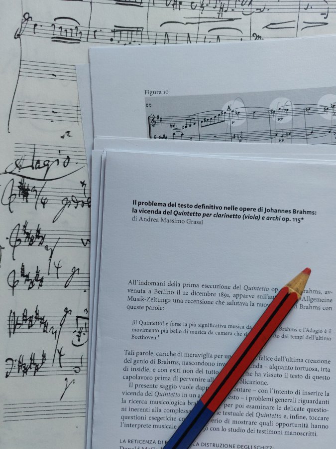 Il tavolo di lavoro: fogli di appunti, matite rossa e blu e una partitura
