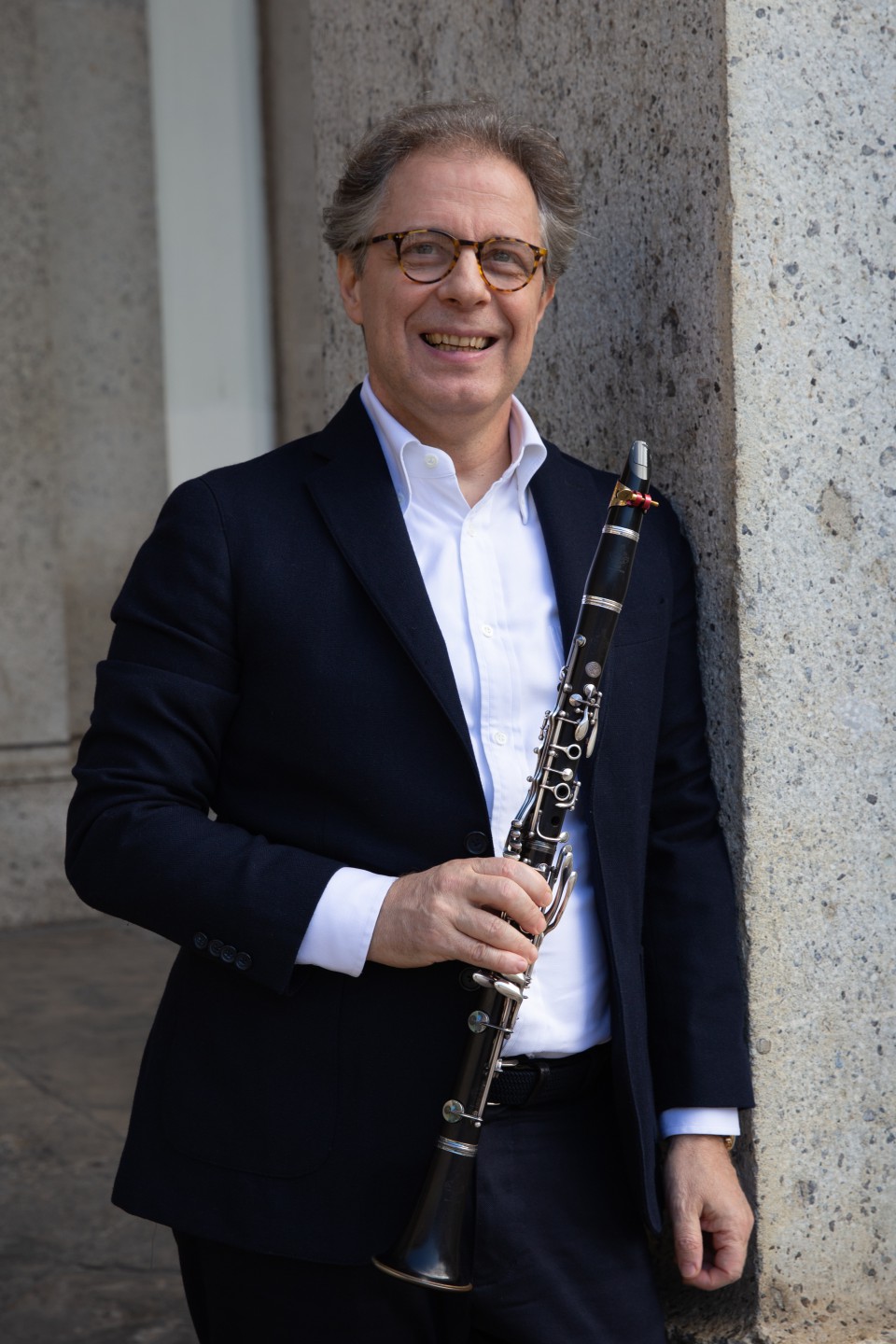 Andrea Massimo Grassi suona il clarinetto al leggio, su fondo scuro